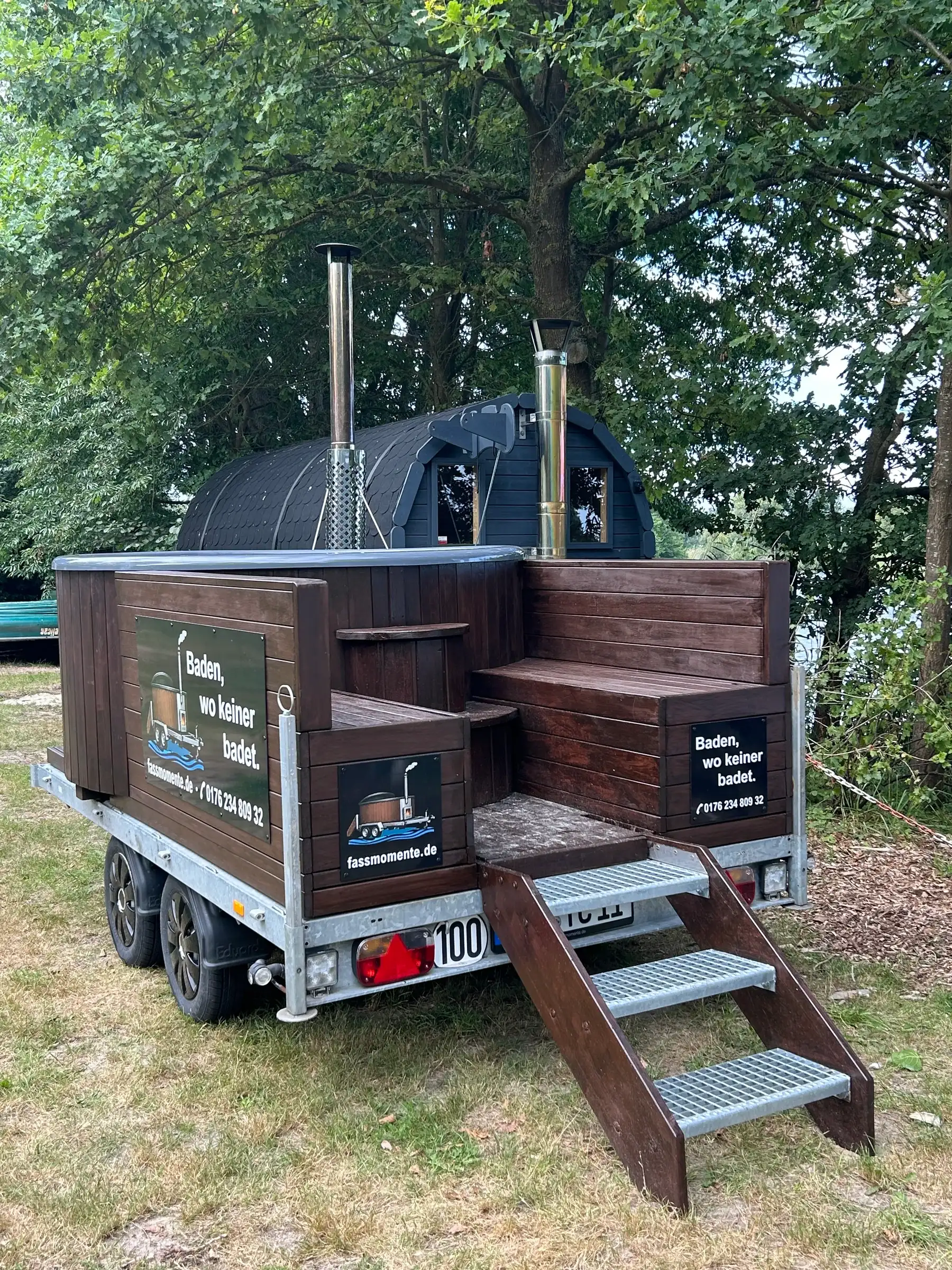 Whirlpool aus dunklem Holz auf dem Anhänger mit Treppe und Ofen